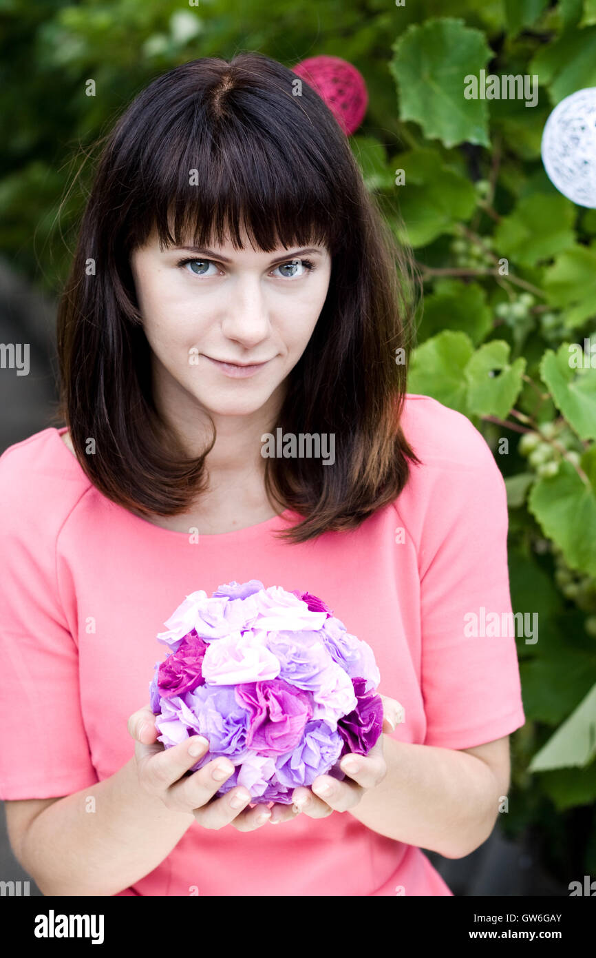 The girl in a pink dress holding a bouquet of purple flowers Stock ...