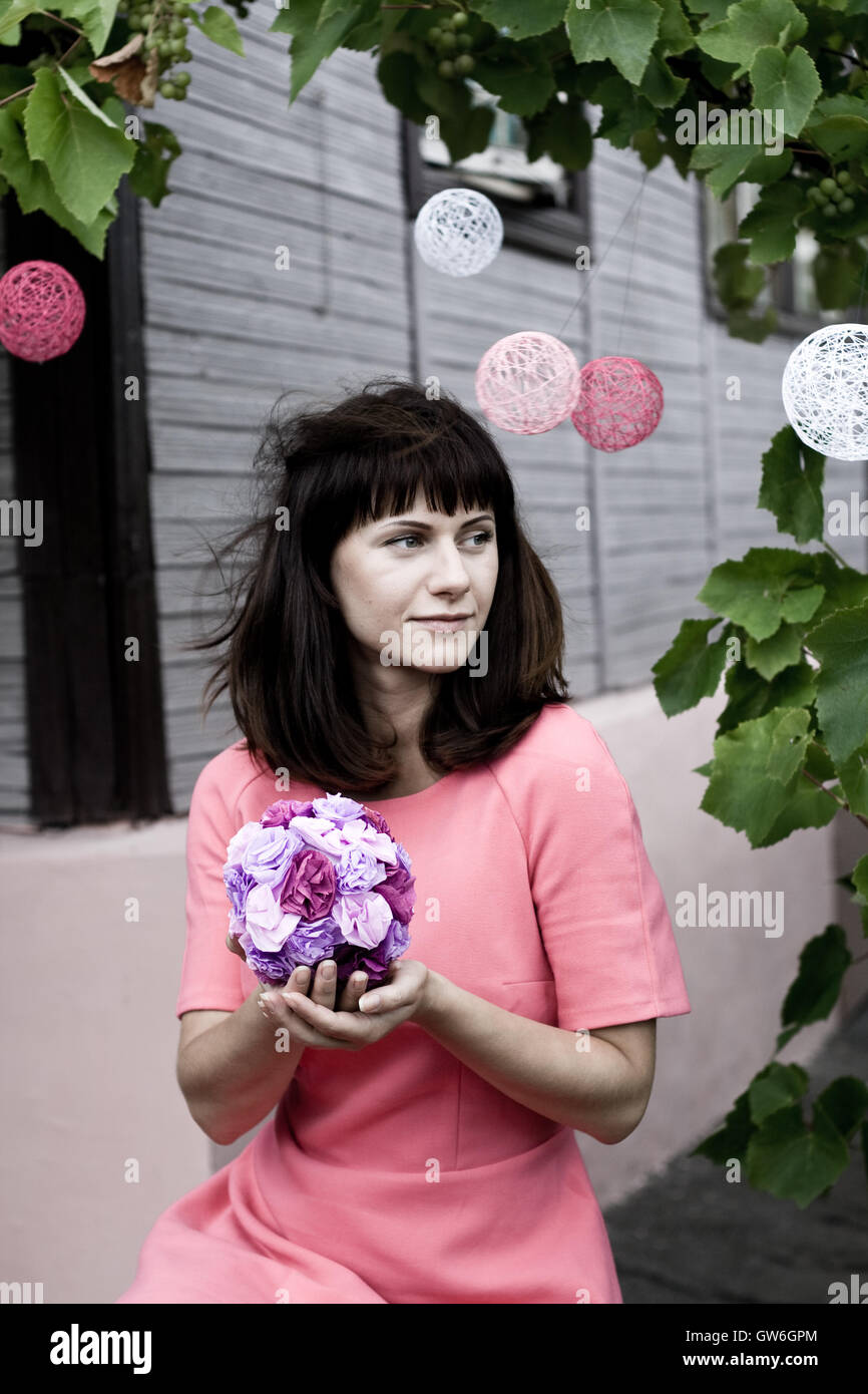 The girl in a pink dress holding a bouquet of purple flowers Stock ...