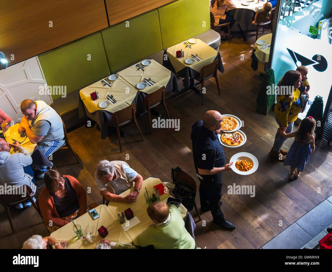 Interior of Sambuca Italian  Café Restaurant waiter delivering food to a table Stock Photo