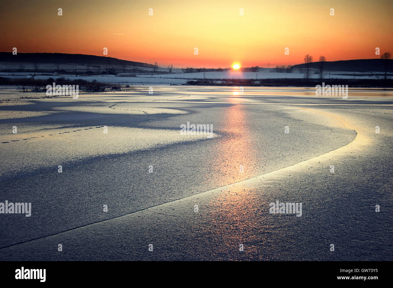 vivid sunset on frozen lake Stock Photo