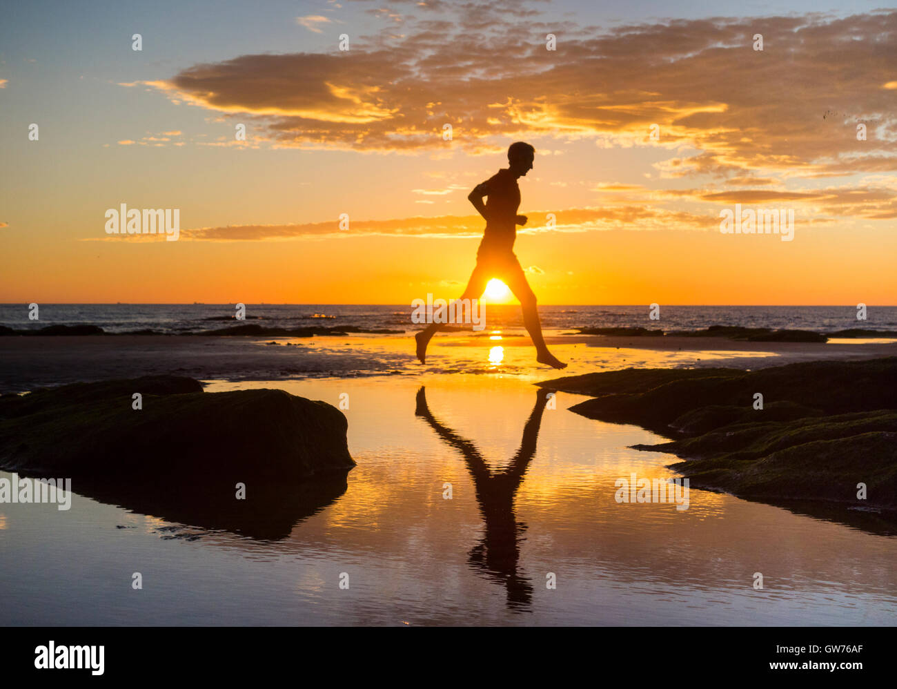 man-jogging-on-beach-at-sunrise-stock-photo-alamy