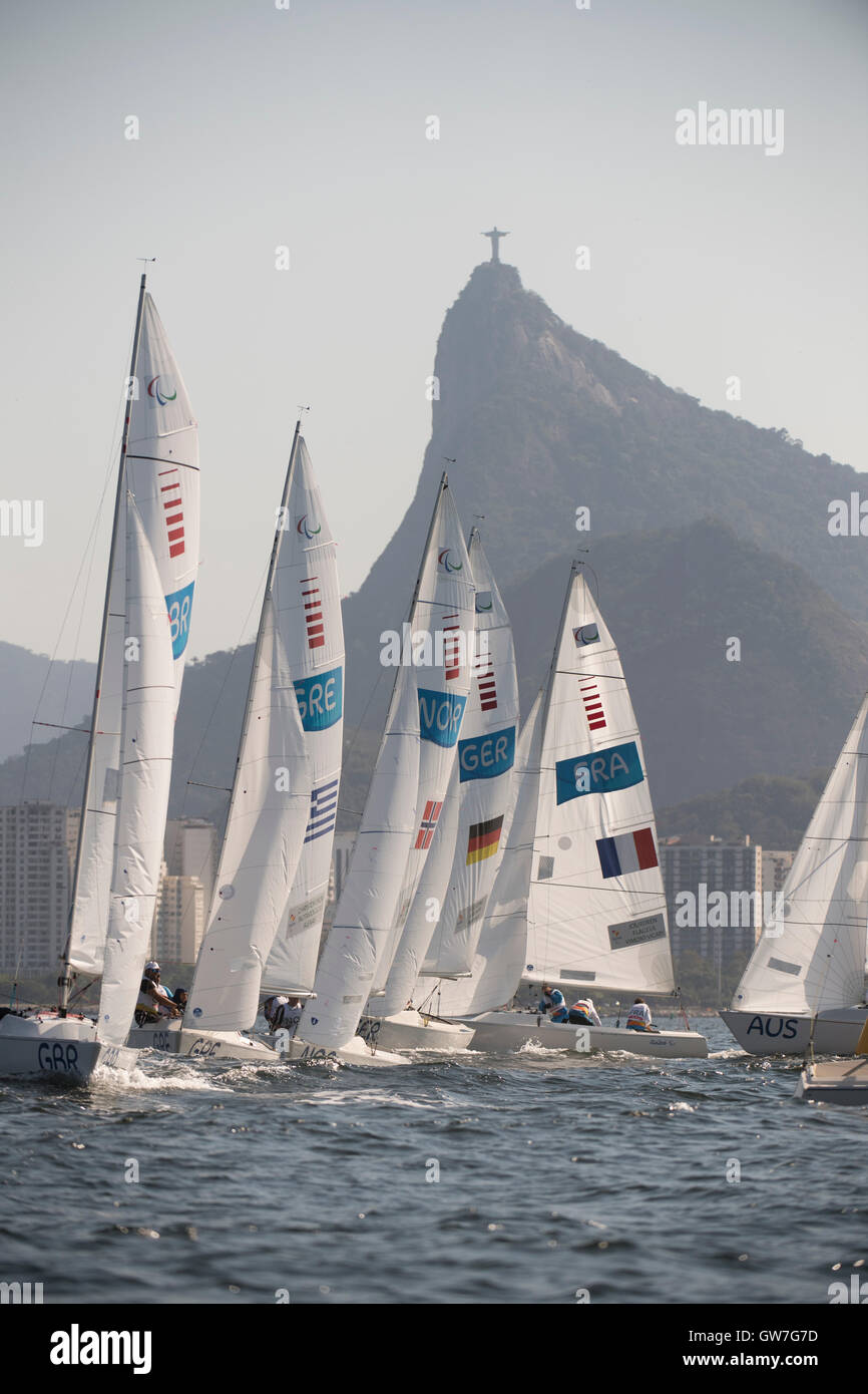 3-person keelboat Sonar class boats race on Guanabara Bay during sailing competition at  the 2016 Paralympics. Stock Photo