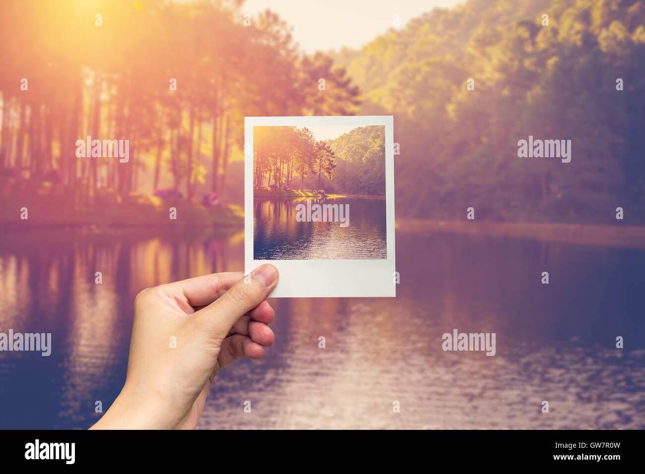 hand hold instant photo Pond water and sunrise with vintage effect. Stock Photo