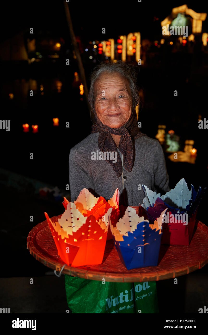 Elderly woman selling floating candle lanterns, Hoi An (UNESCO World Heritage Site), Vietnam Stock Photo