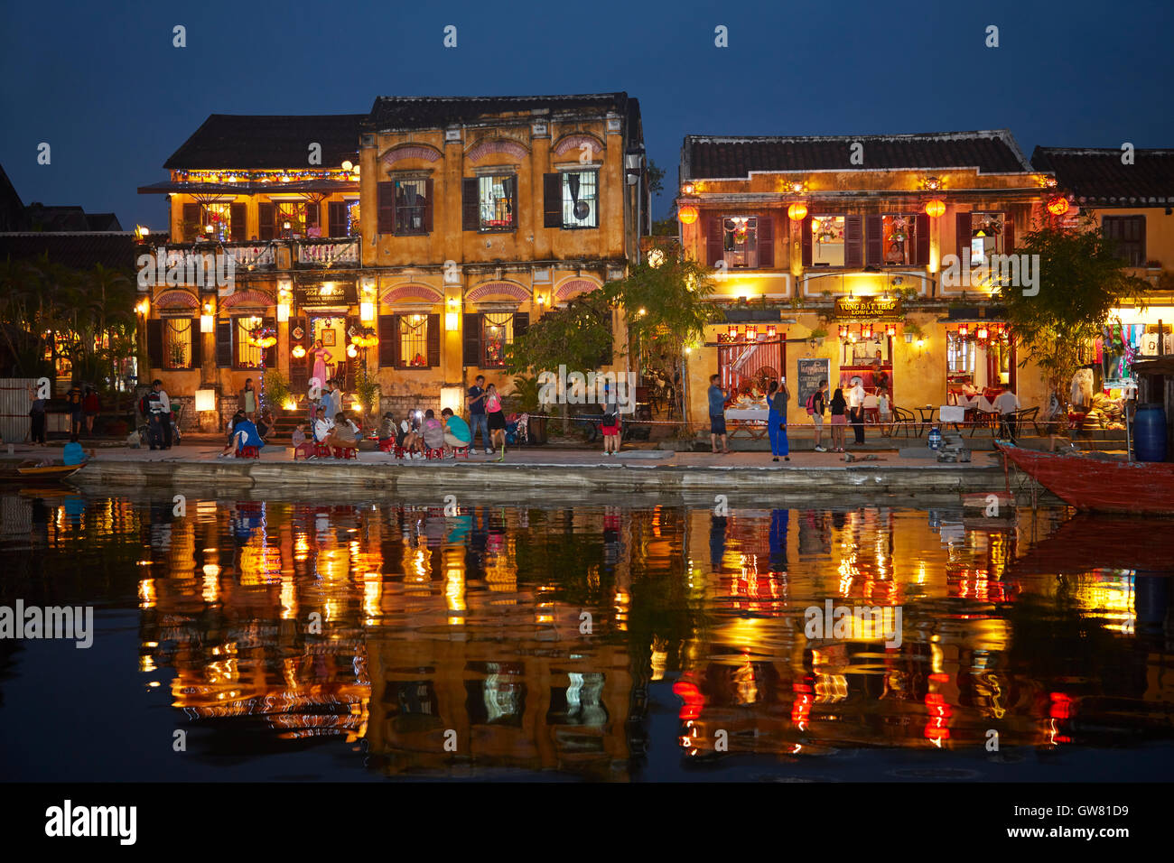 Restaurants and tourists reflected in Thu Bon River at dusk, Hoi An (UNESCO World Heritage Site), Vietnam Stock Photo