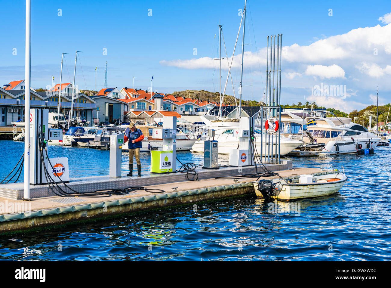 Marstrand, Sweden - September 8, 2016: Male fisherman at a marine fueling station to refuel the small motorboat. Real people in Stock Photo