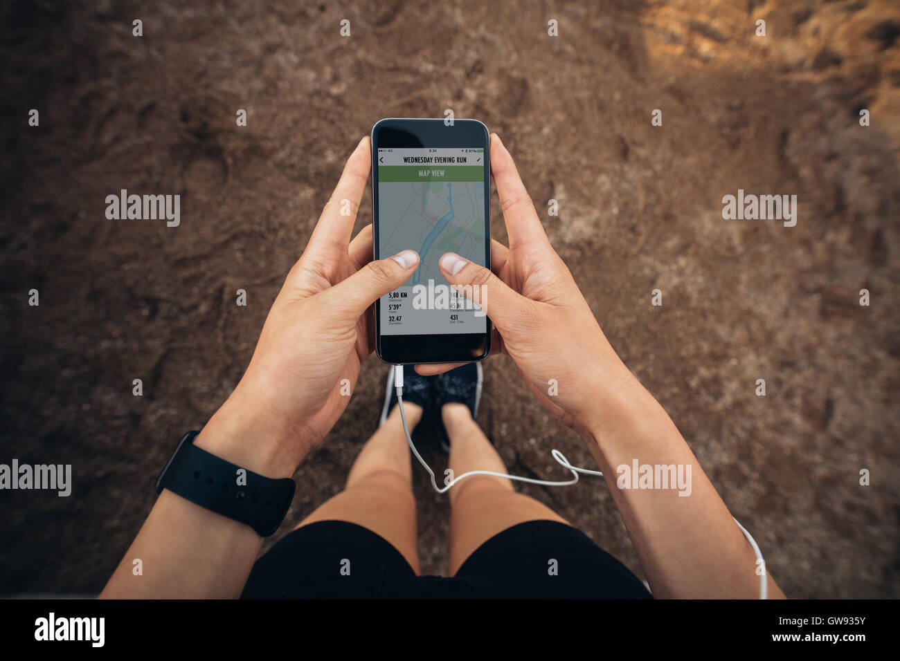 Woman checking the summary of her run on smartphone. POV shot of woman runner using a fitness app on her cellphone. Stock Photo