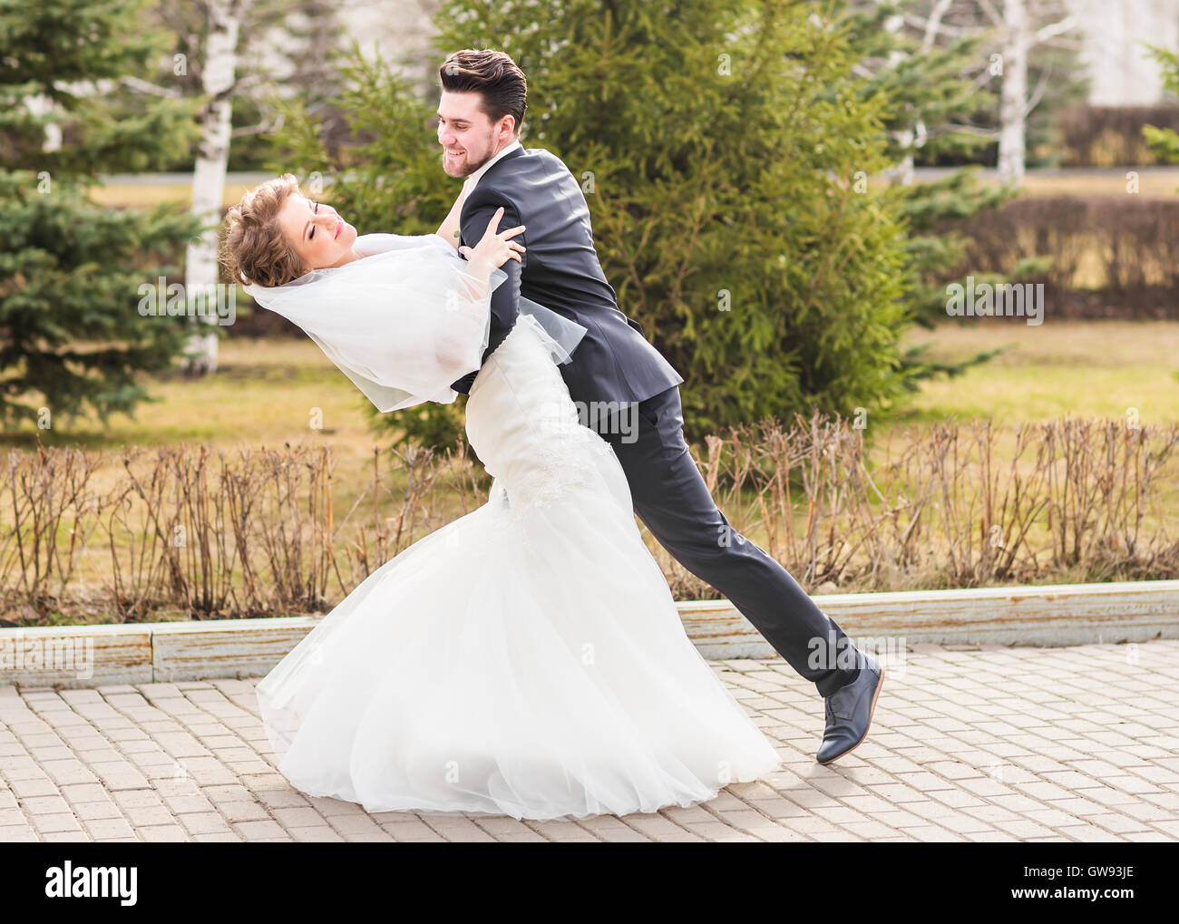groom holding bride in dance pose on wedding day GW93JE