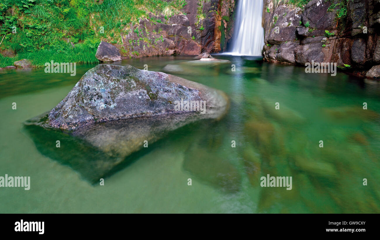 Portugal: Waterfall with natural pool and huge rock in transparent water Stock Photo