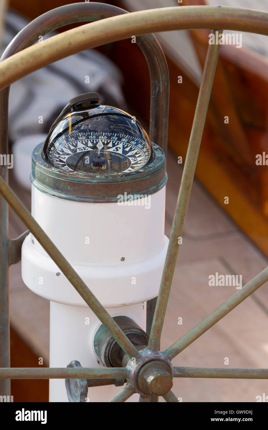 Compass and helm wheel on a classic sailing yacht Stock Photo Alamy
