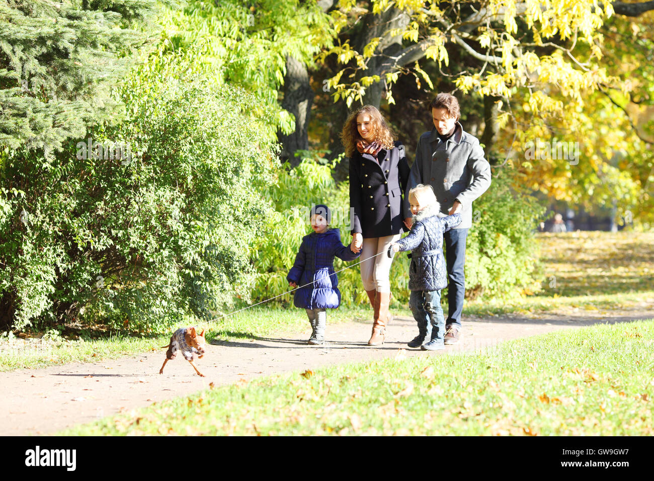 Happy family walking in autumn park at sunny day Stock Photo - Alamy