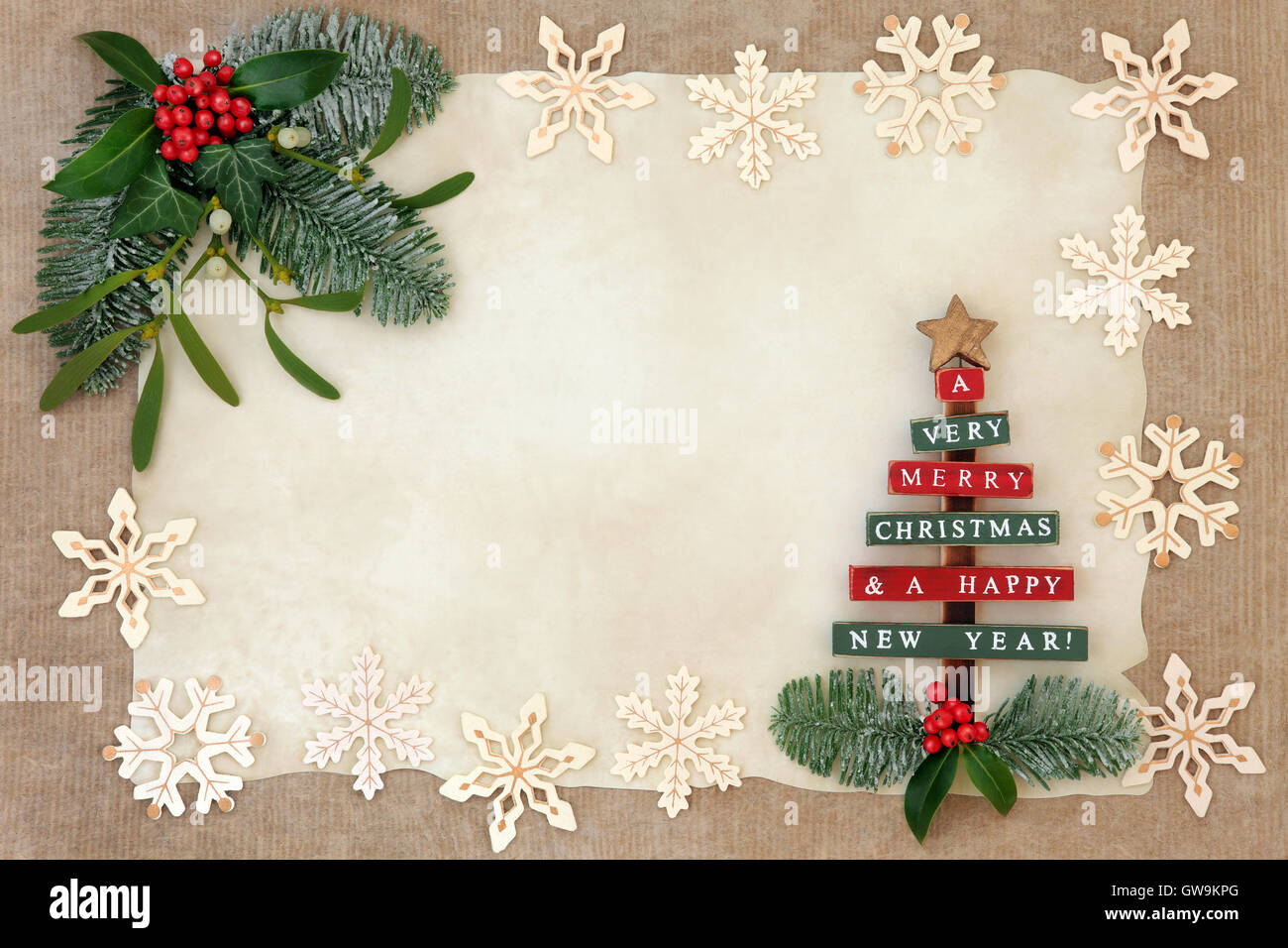 Christmas abstract background border with old wooden tree and snowflake decorations, holly, ivy, mistletoe and snow covered fir Stock Photo