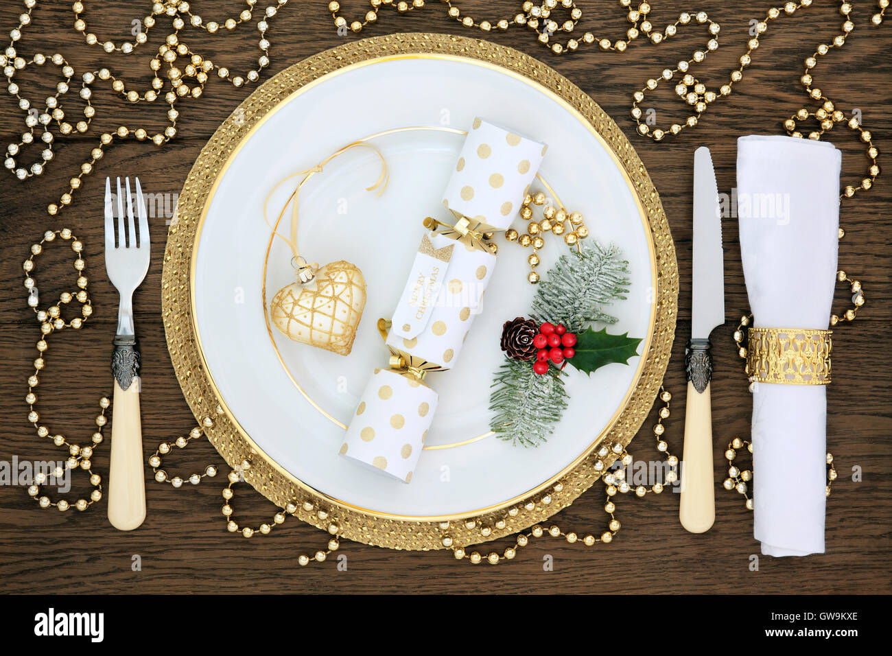 Christmas dinner table setting with white porcelain plate, cracker ...