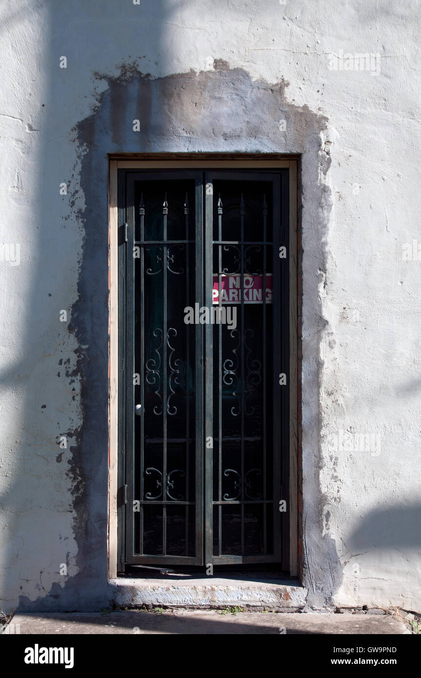 Distressed Door Behind An Iron Security Gate With A No