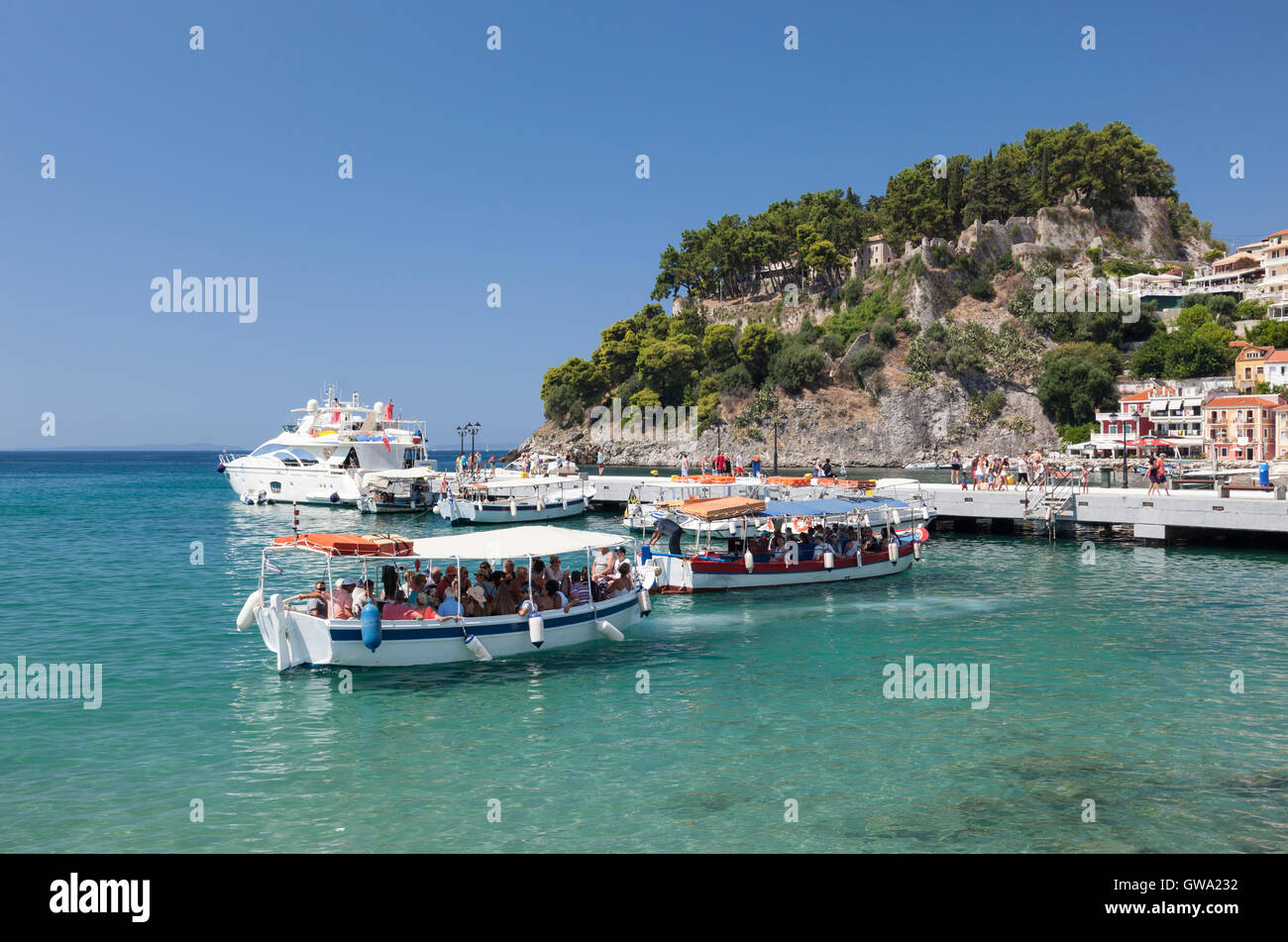 Tourist boats in the picturesque port of Parga with Parga castle as a backdrop, Greece Stock Photo