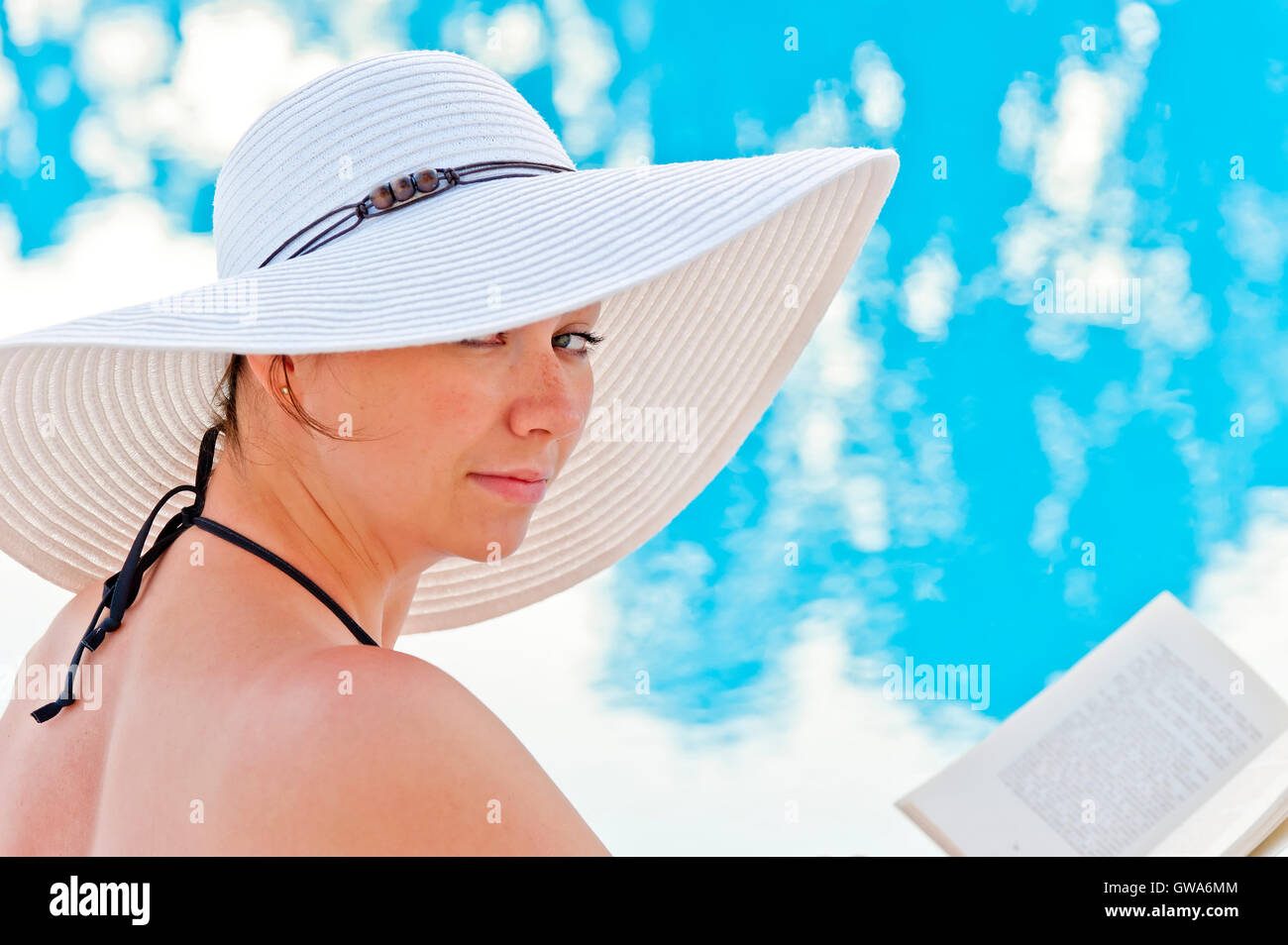 portrait of a beautiful woman sitting with a book by the pool Stock ...
