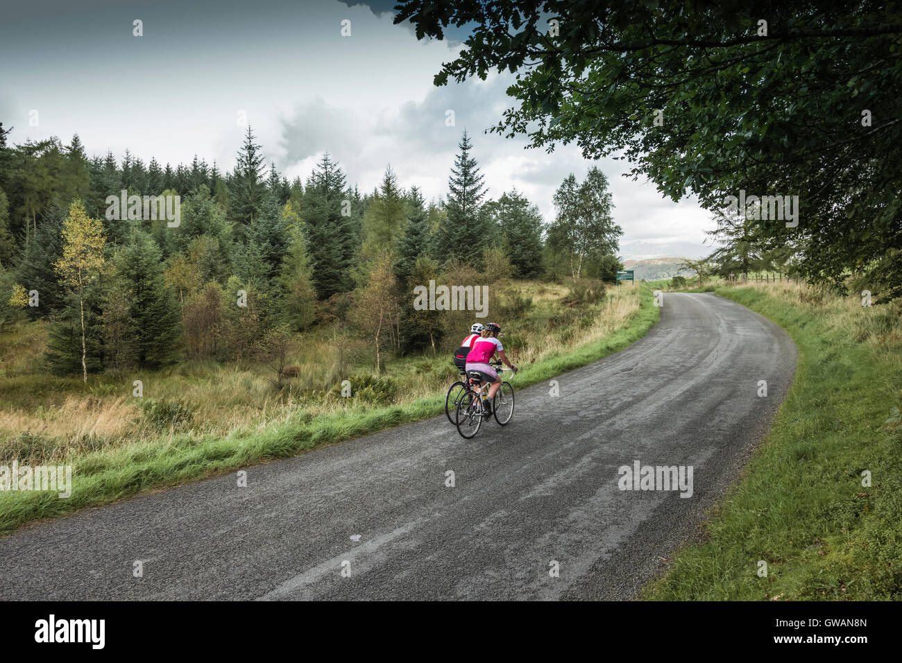 Two women cyclist cresting a hill in the English Lake District, Cumbria