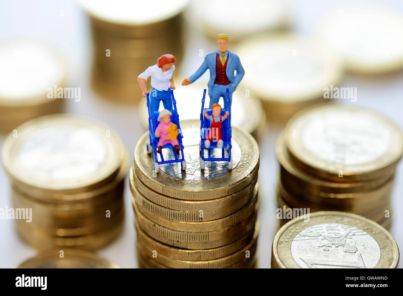 Miniature figures of a family on a coin pile, symbolic photo family money, Miniaturfiguren einer Familie auf einem Muenzstapel, Stock Photo