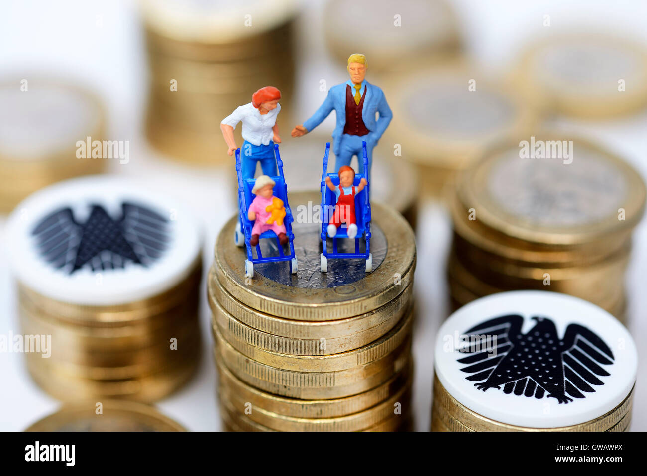 Miniature figures of a family on a coin pile, symbolic photo family money, Miniaturfiguren einer Familie auf einem Muenzstapel, Stock Photo