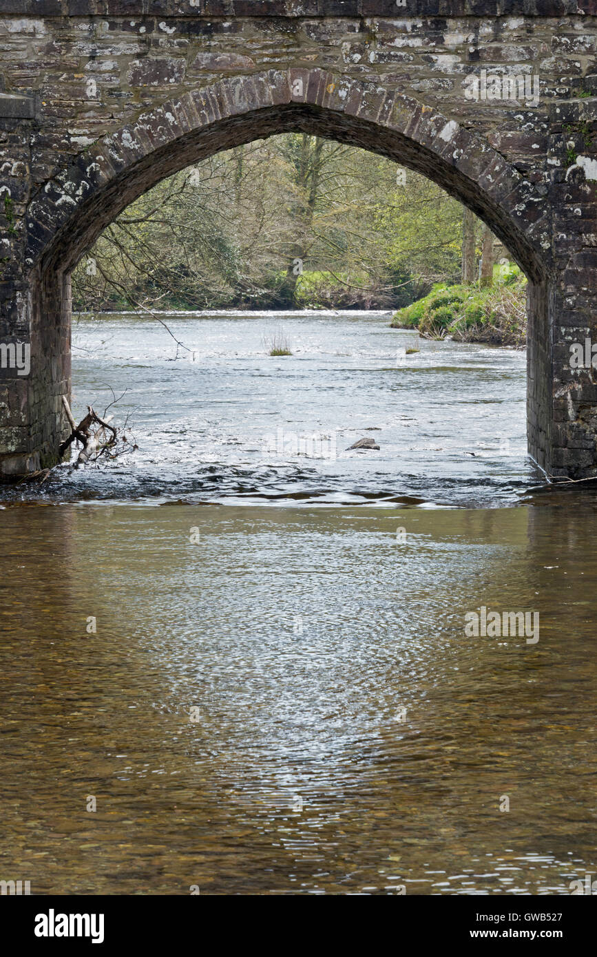 Looking through an arch of the road bridge over the river Barle in the village of Dulverton on Exmoor in Somerset Stock Photo