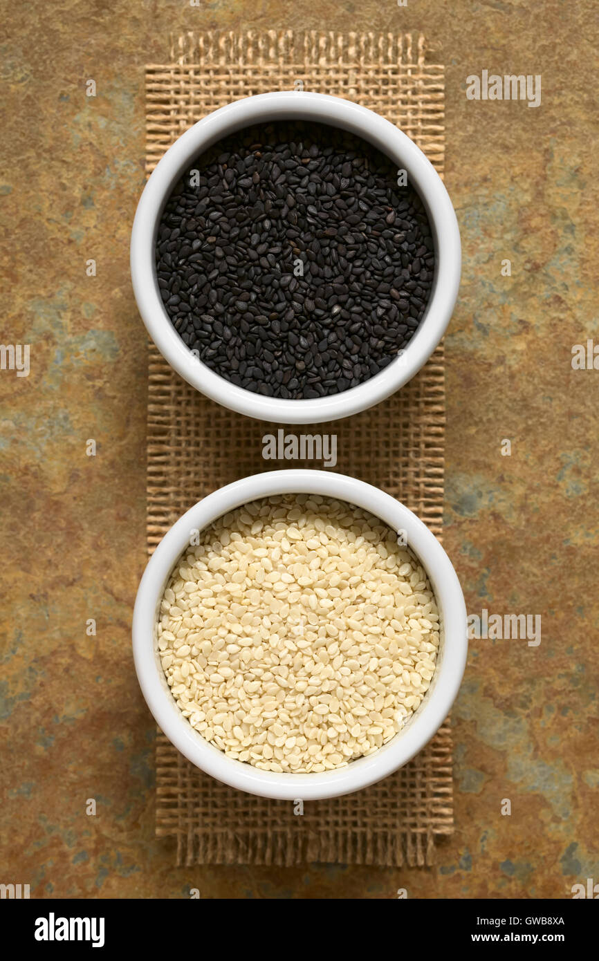 Black and white sesame seeds in small bowls, photographed overhead with natural light (Selective