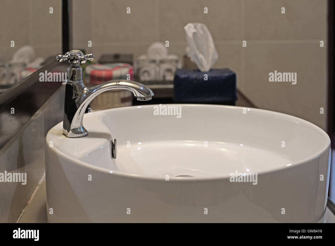 ceramic washbasin and metal faucet in bathroom Stock Photo