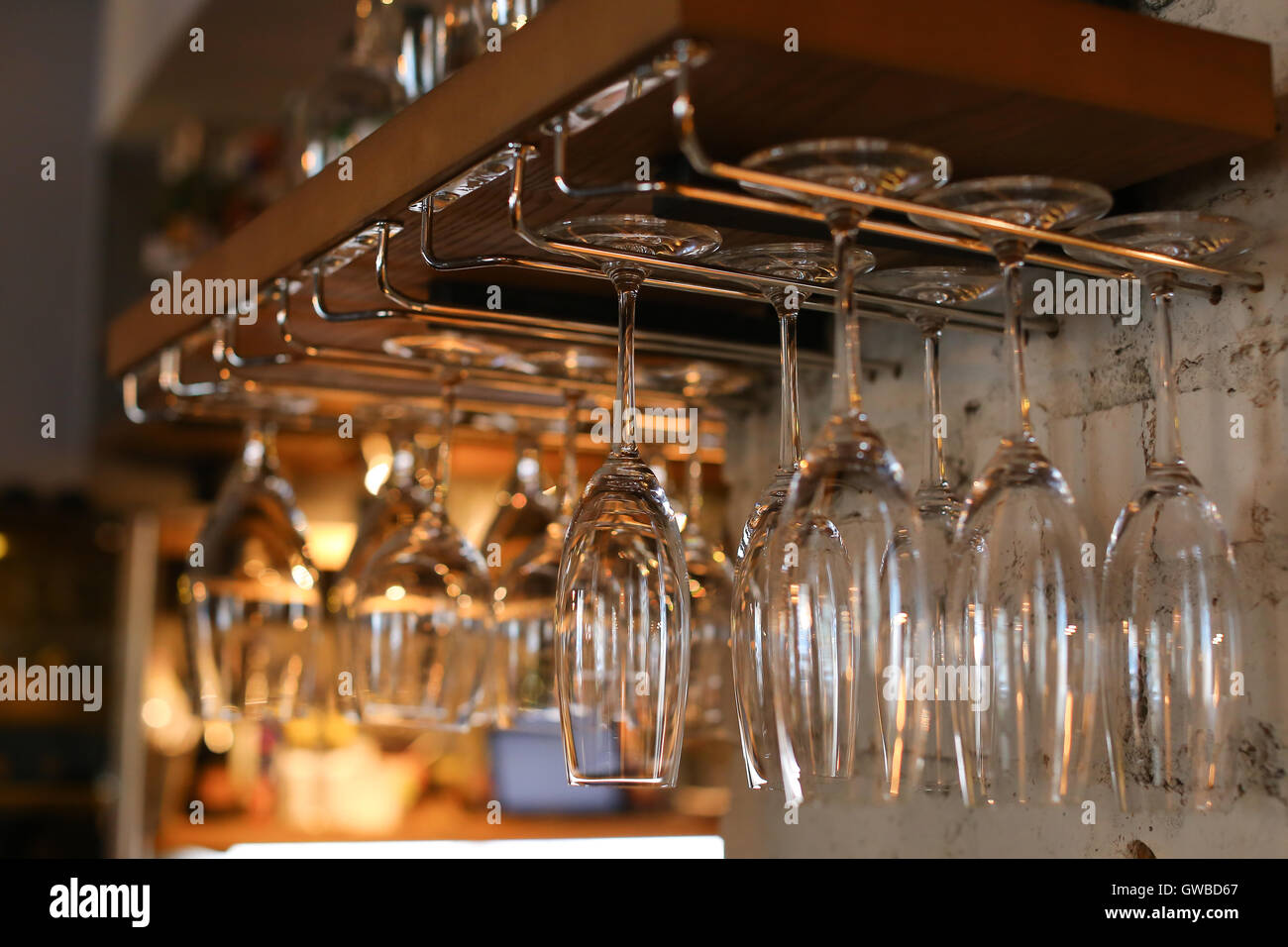 Wineglasses hanging on glass drying rack Stock Photo by seventyfourimages