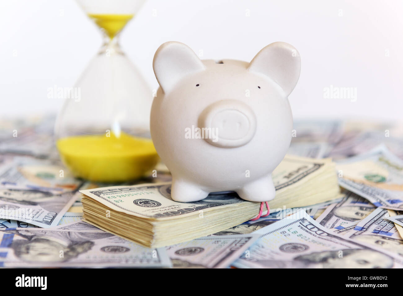 pig money box with sand-glasses and cash Stock Photo