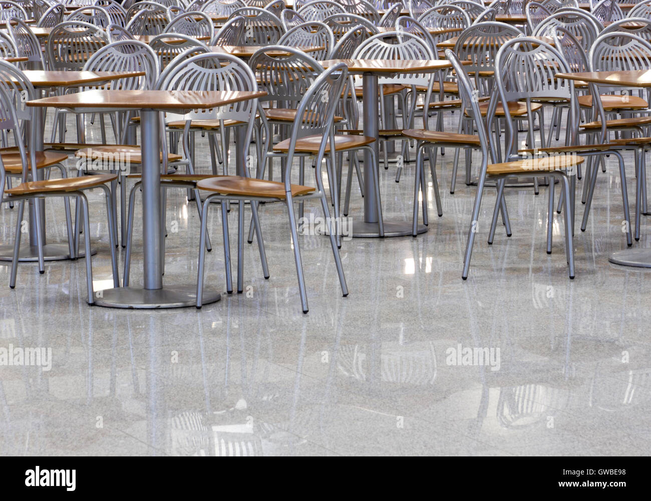 Interior of a modern contemporary fast food cafe or restaurant with chairs, tables and floor of stone which reflections. Stock Photo