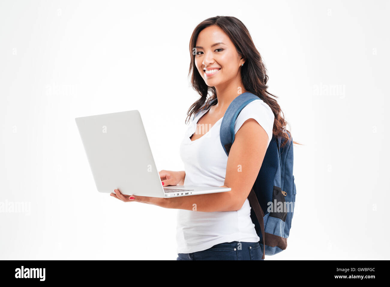 Happy cute asian student girl with backpack standing and holding laptop ...