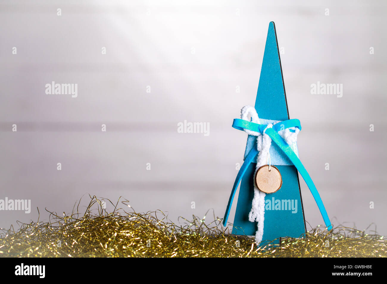 Wooden christmas tree on gold bokeh background. Decorative xmas card with copy space. Stock Photo