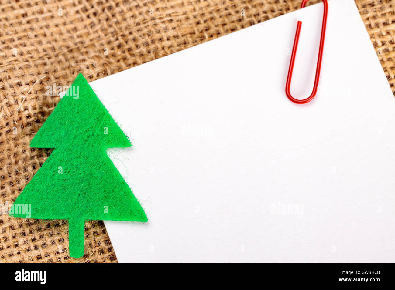 Blank card with christmas felt decorations on jute background. Stock Photo