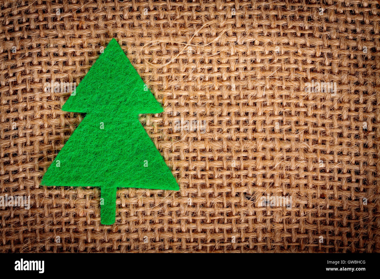 Felt christmas decorations on jute background with copy space. Stock Photo