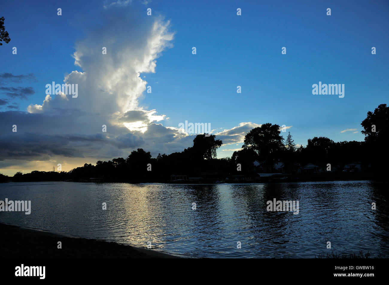 River silhouetted against unusual backlit cloud. Stock Photo