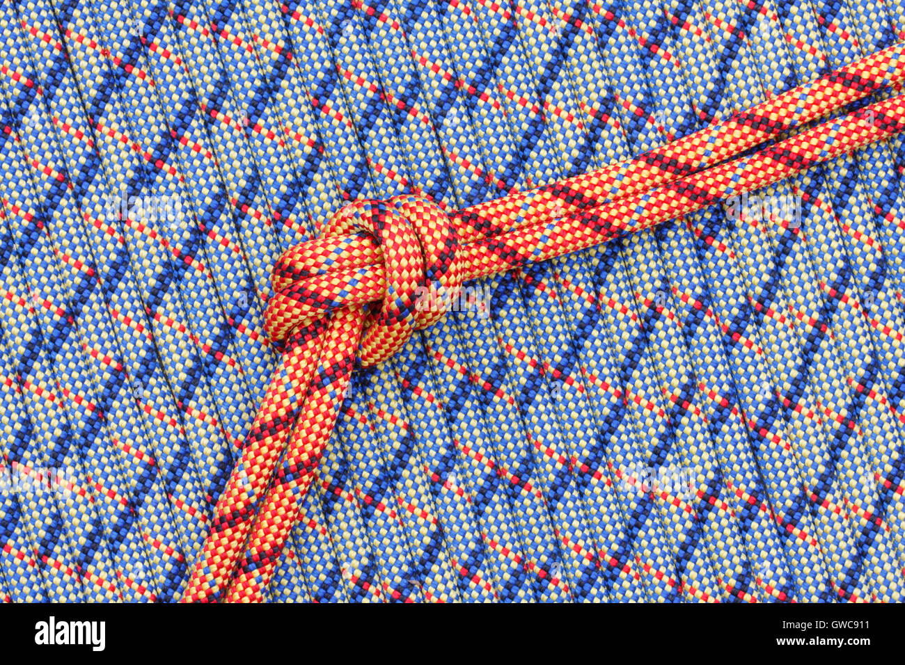 Bright colored rope with a overhand knot on a background of ropes Stock Photo
