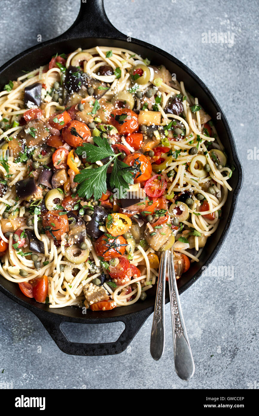An eggplant pomodoro pasta dish is photographed in a cast iron skillet right after it was cooked. Stock Photo