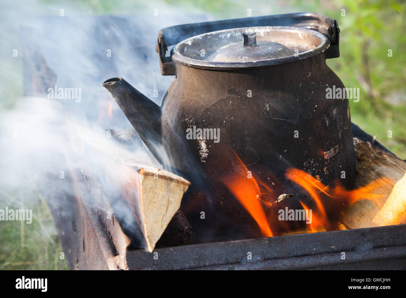 https://c8.alamy.com/comp/GWCJHH/old-used-black-boiling-teapot-on-bonfire-GWCJHH.jpg
