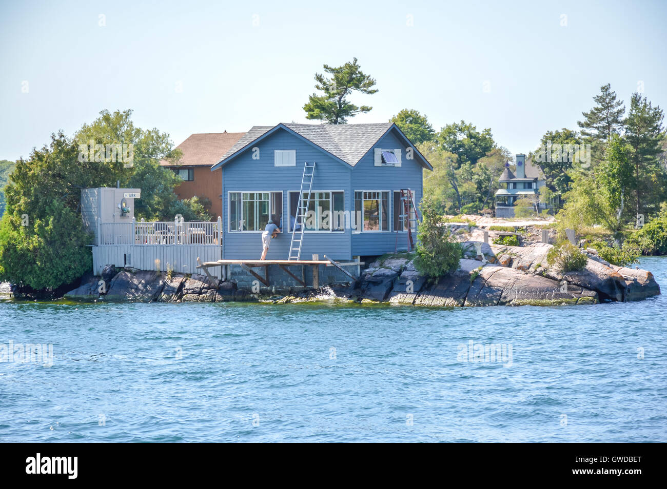 One Island with the blue house in Thousand Islands Region in summer in Kingston, Ontario, Canada Stock Photo