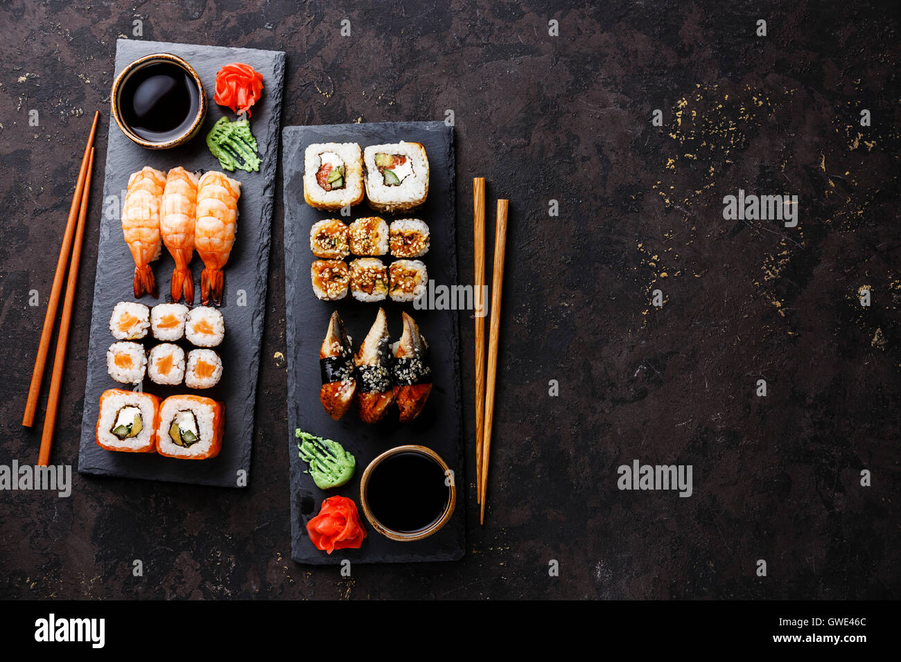 Sushi rolls, maki, nigiri Set served for two on black stone slate on dark background Stock Photo