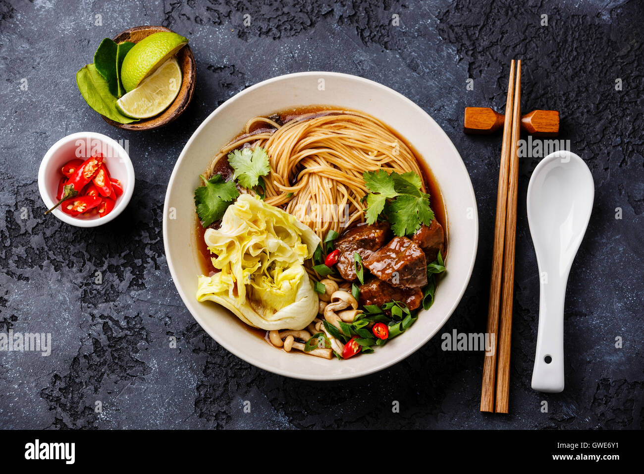 Spicy asian noodles in broth with Beef on dark background Stock Photo