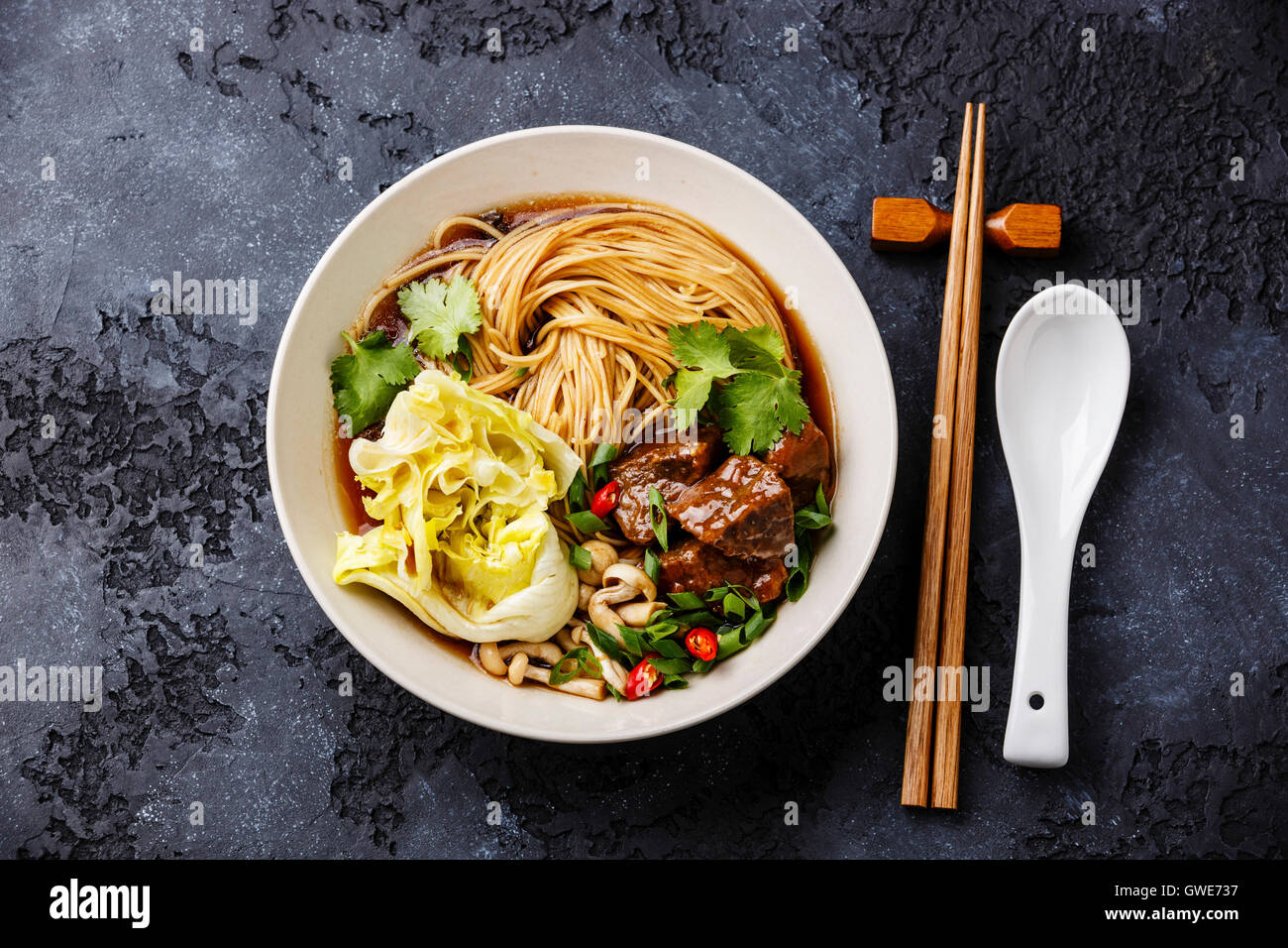 Spicy asian noodles in broth with Beef on dark background Stock Photo