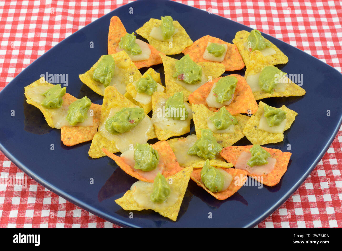 Nachos with cheese and guacamole on blue plate Stock Photo