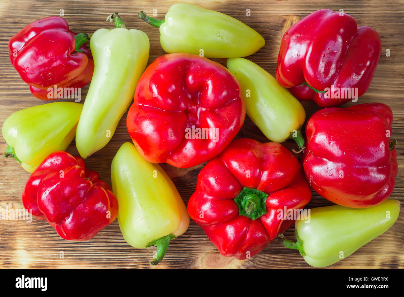 Vegetable still life of mature red and green peppers on wooden background Stock Photo