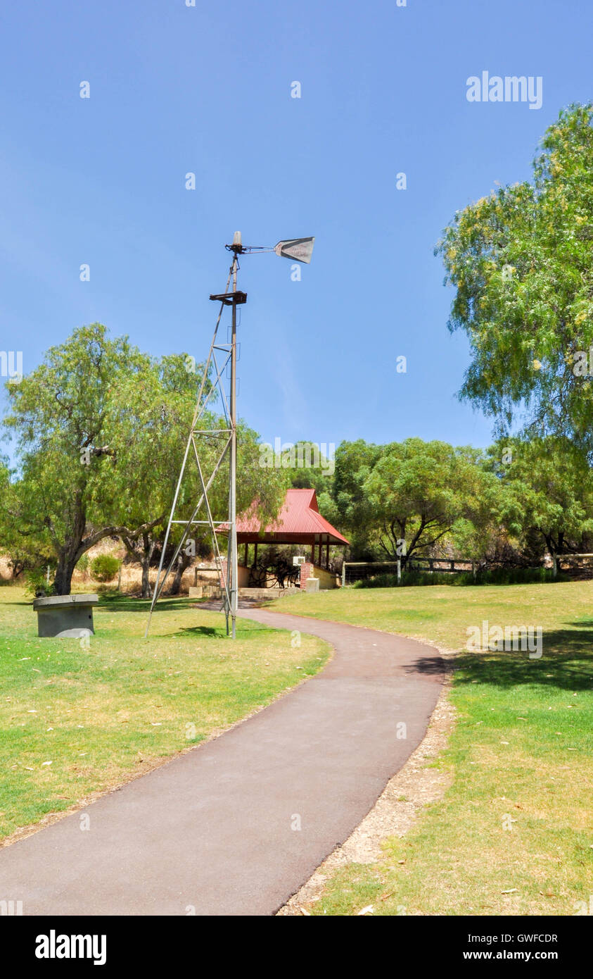Tall metal weather vane in outdoor Manning Park setting with pedestrian