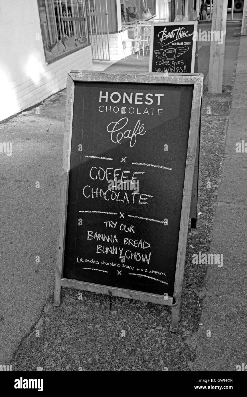 Honest Chocolate Cafe signboard on pavement in Wale Street, Cape Town, South Africa.(black and white photograph) Stock Photo
