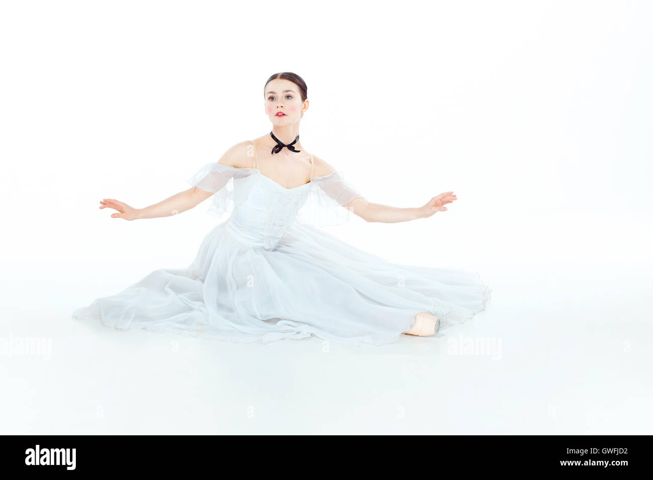 Ballerina in white dress sitting, studio background Stock Photo - Alamy