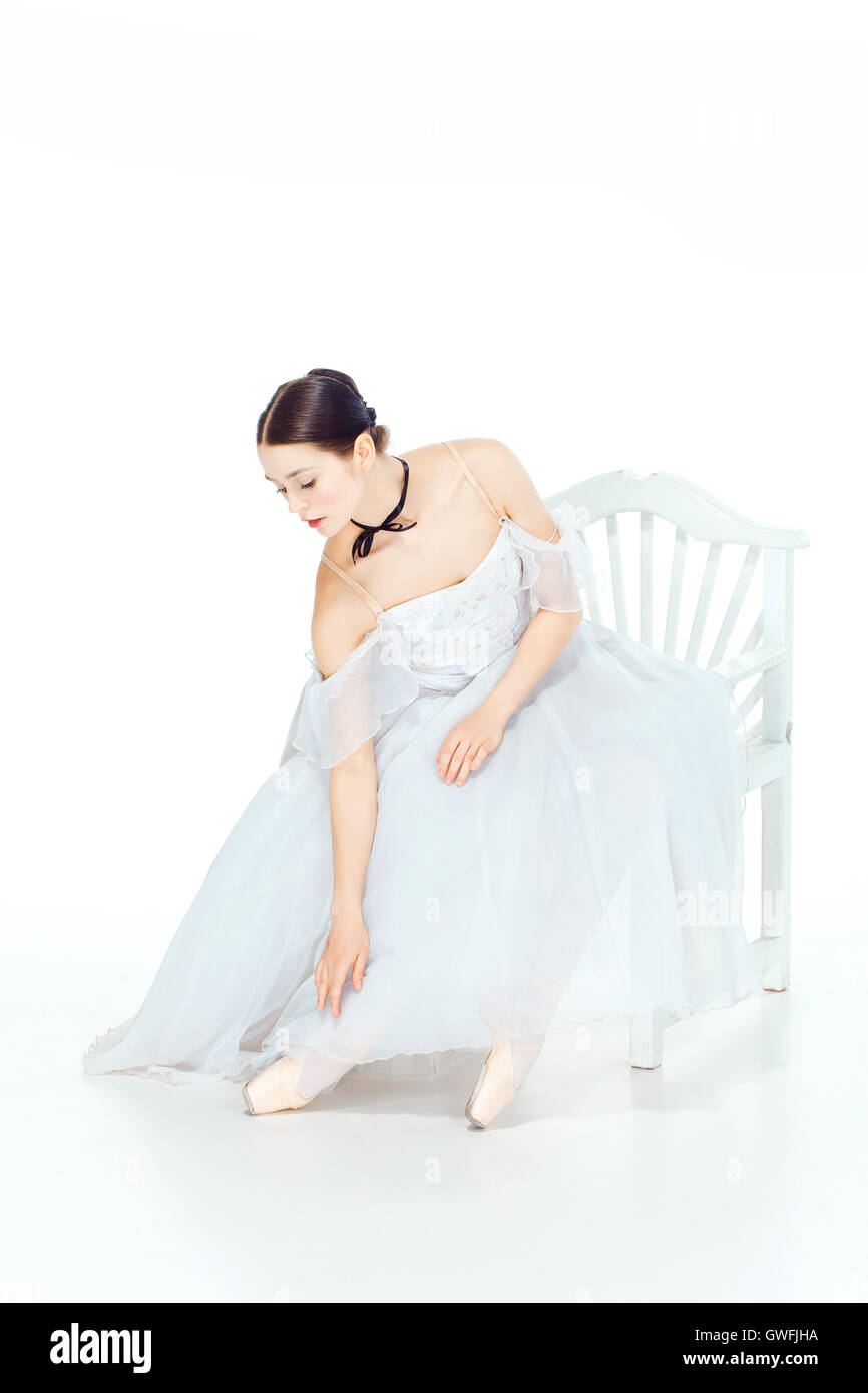 Ballerina in white dress sitting, studio background Stock Photo - Alamy