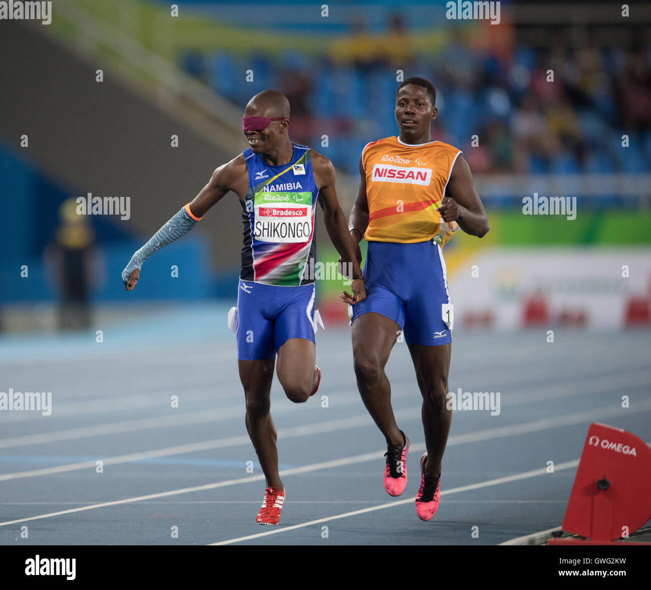 Ananias Shikongo of Namibia and guide runner win heat of the 200 meters T11 to qualify for the final at the Rio Paralympics. Stock Photo