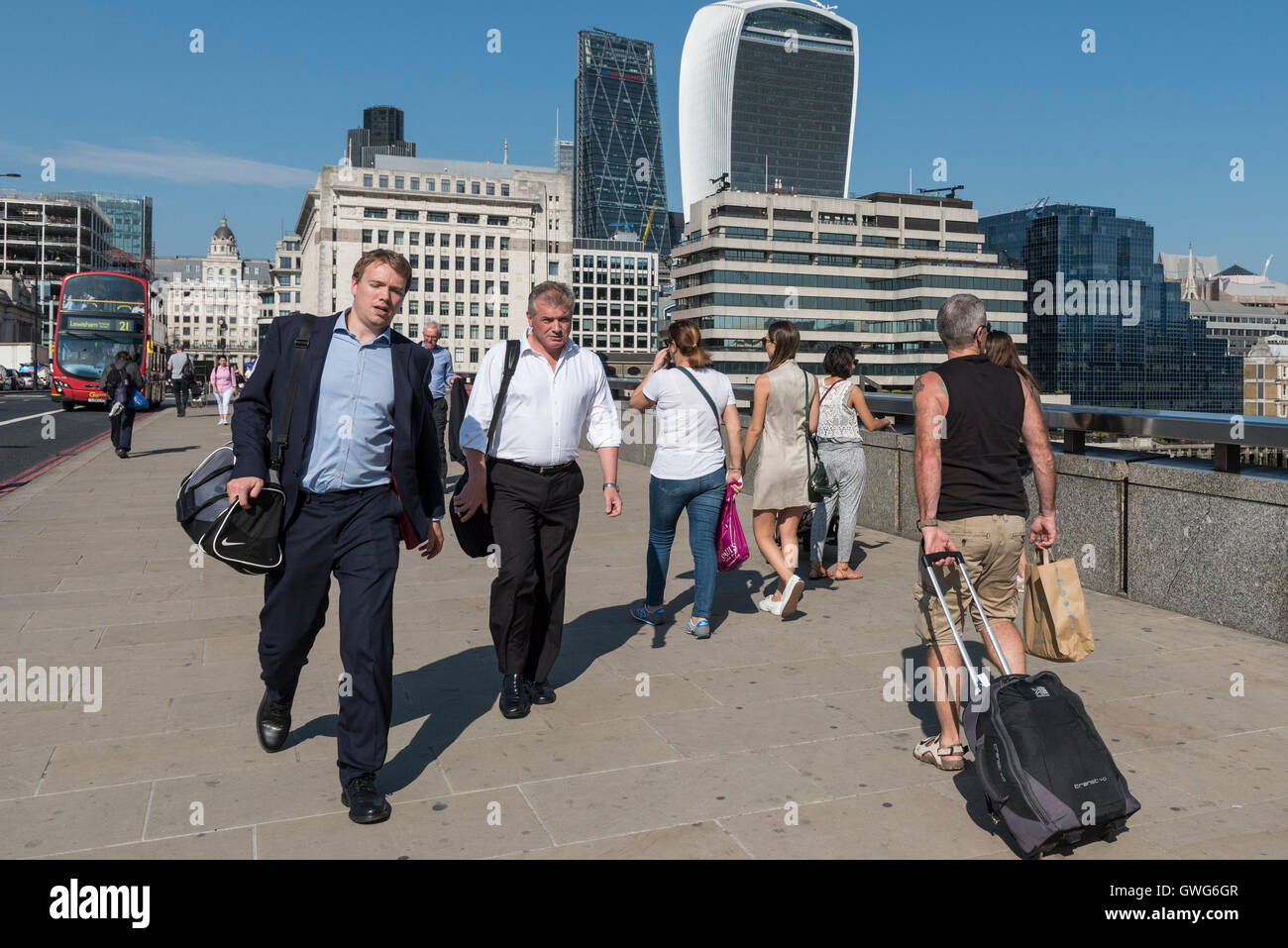 London, UK.  14 September 2016.  City workers cross London Bridge on their journeys home as the September mini-heatwave continues.  Whilst women's dress codes are more relaxed in the Square Mile, men must retain a certain formality however uncomfortable they might be when the temperatures rise. Credit:  Stephen Chung / Alamy Live News Stock Photo