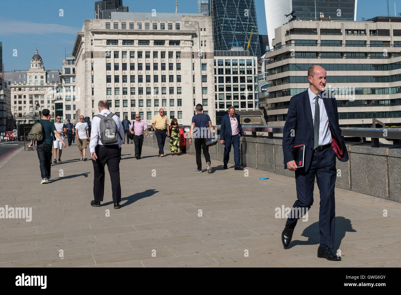 London, UK.  14 September 2016.  City workers cross London Bridge on their journeys home as the September mini-heatwave continues.  Whilst women's dress codes are more relaxed in the Square Mile, men must retain a certain formality however uncomfortable they might be when the temperatures rise. Credit:  Stephen Chung / Alamy Live News Stock Photo